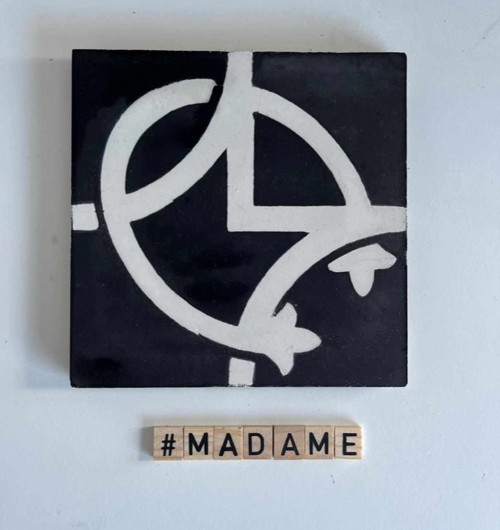 Motif Madame : carreau noir au monogramme blanc de l'atelier